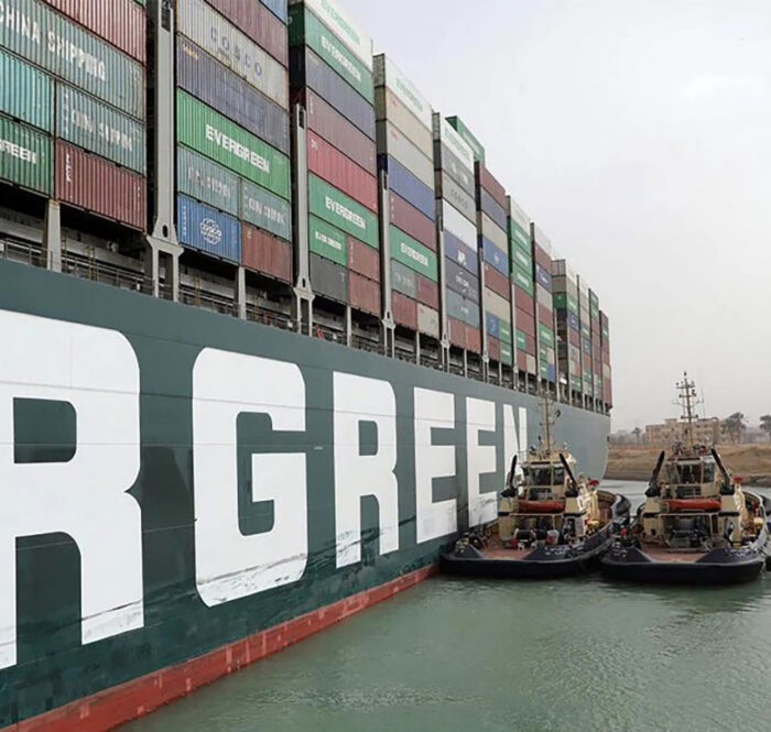 Các tàu kéo cố gắng giải phóng tàu hàng Ever Given mắc kẹt giữa kênh đào Suez hôm 25/3. (Ảnh: AFP)