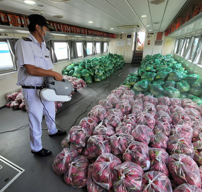 Nhân viên tàu khử khuẩn hàng hóa. Ảnh: Hoàng Thanh.