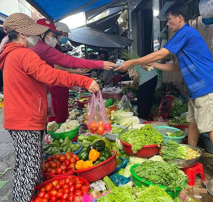 Khách hàng mua hành, rau quả tại chợ truyền thống ở TP HCM. Ảnh: Hồng Châu