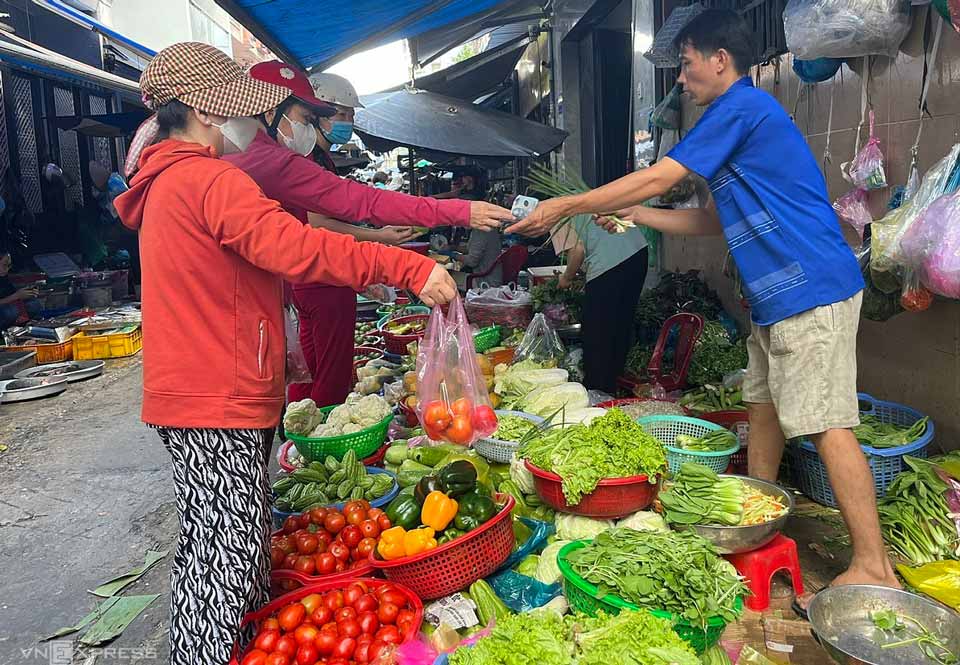 Khách hàng mua hành, rau quả tại chợ truyền thống ở TP HCM. Ảnh: Hồng Châu